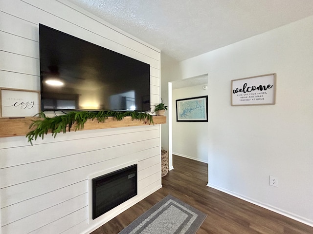 unfurnished living room featuring dark hardwood / wood-style flooring and a textured ceiling