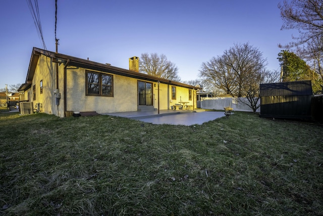 back of property featuring a patio, a yard, fence, and stucco siding