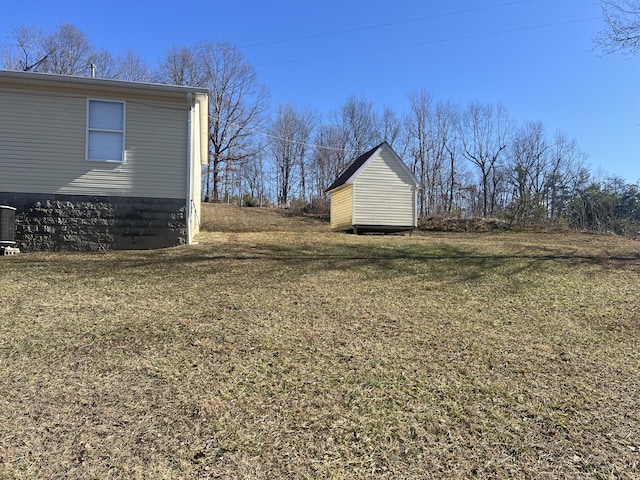 view of yard with central AC unit and a storage shed