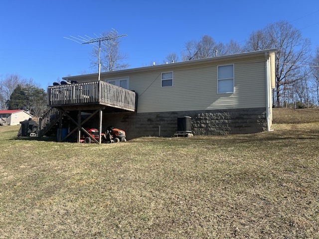 back of property featuring a wooden deck and a lawn