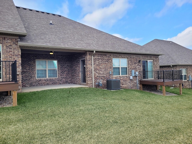 rear view of property featuring a patio, a deck, a lawn, and central air condition unit