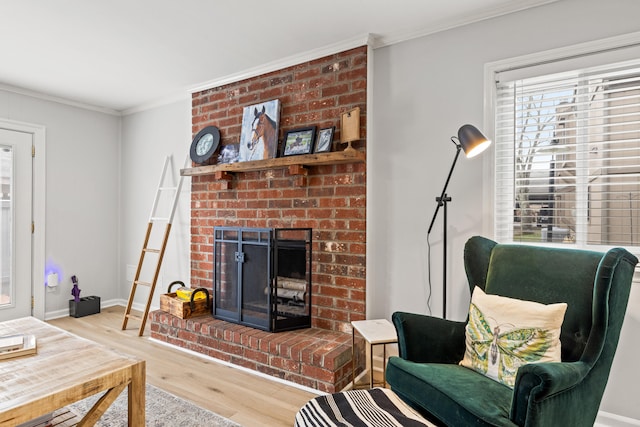 living room featuring a fireplace, ornamental molding, and light hardwood / wood-style floors