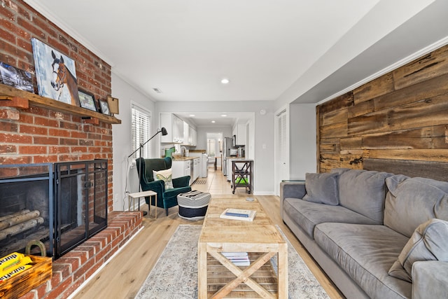 living room featuring sink, a fireplace, and light hardwood / wood-style floors