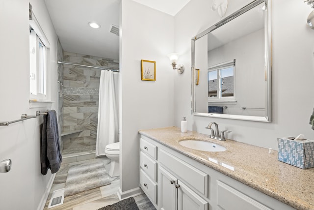 bathroom featuring vanity, curtained shower, and toilet