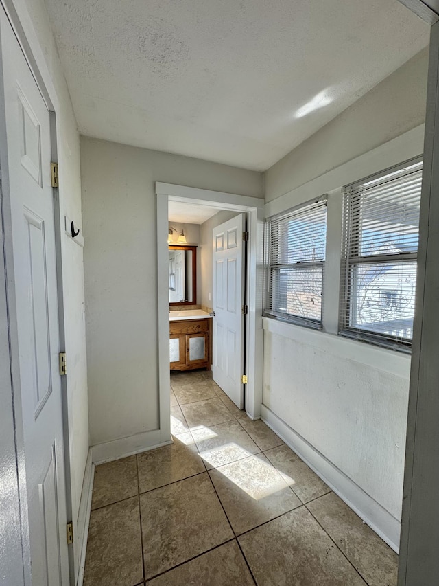 interior space with light tile patterned floors and a textured ceiling