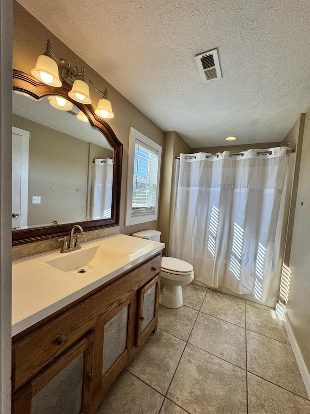 bathroom featuring tile patterned flooring, vanity, a textured ceiling, and toilet