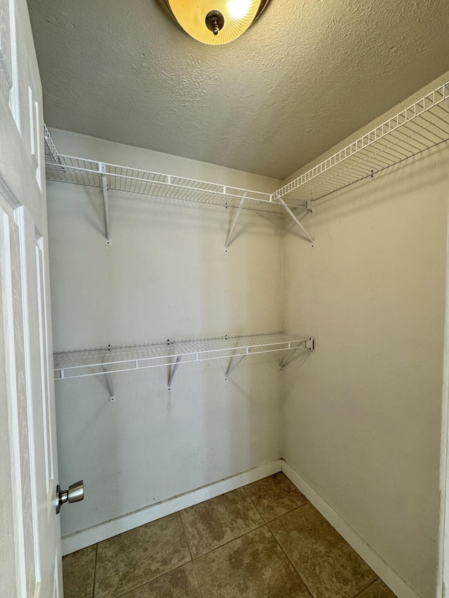 spacious closet with tile patterned floors