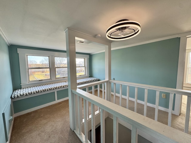 hallway with ornamental molding and carpet flooring