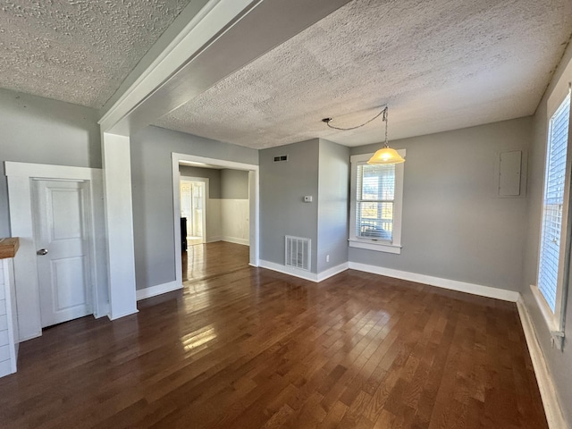 unfurnished dining area featuring dark hardwood / wood-style flooring, electric panel, and a textured ceiling