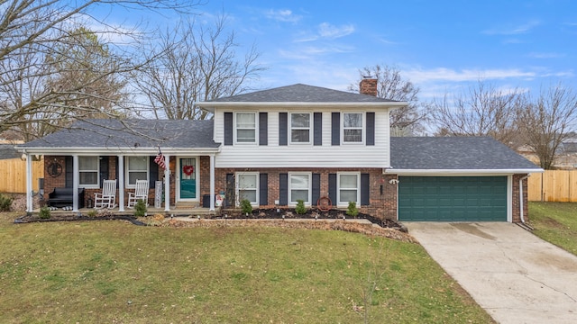 tri-level home with a garage, a porch, and a front yard