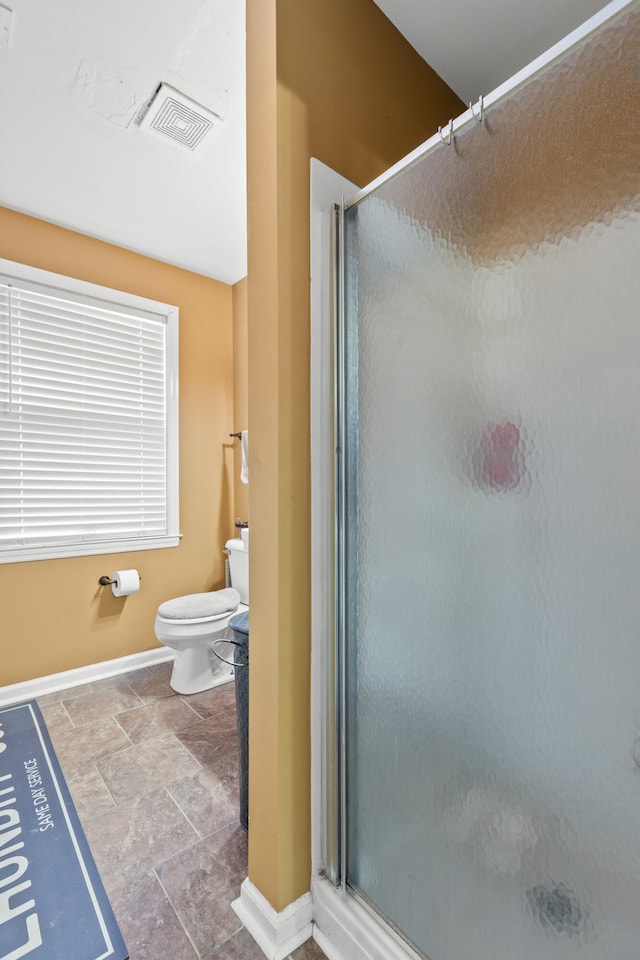 bathroom with an enclosed shower and toilet