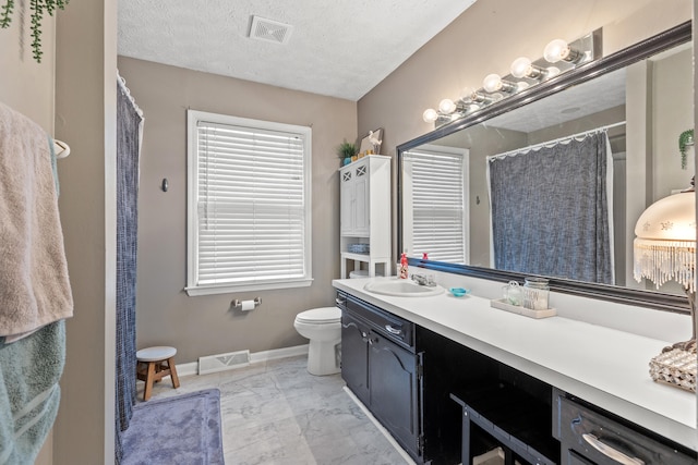 bathroom featuring vanity, a shower with curtain, toilet, and a textured ceiling