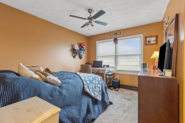 bedroom featuring ceiling fan, light colored carpet, and a textured ceiling