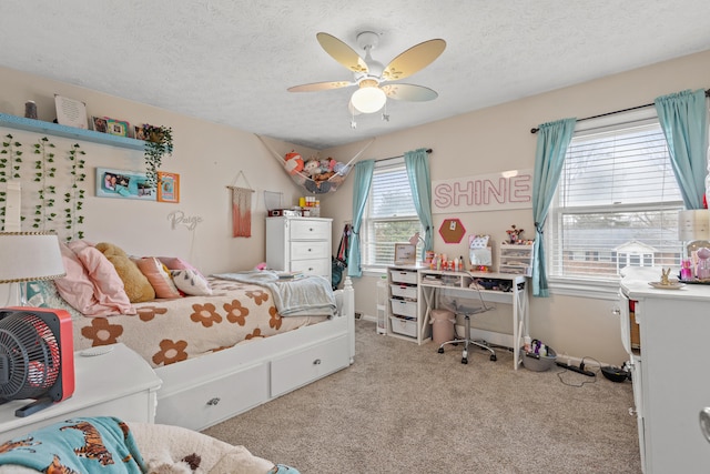 bedroom with light carpet, ceiling fan, and a textured ceiling