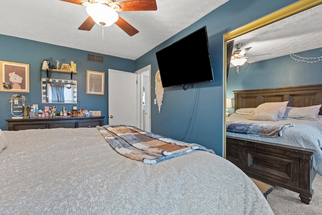 bedroom featuring ceiling fan, carpet floors, and a textured ceiling