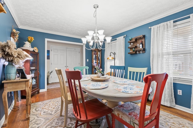 dining area featuring an inviting chandelier, crown molding, and wood-type flooring