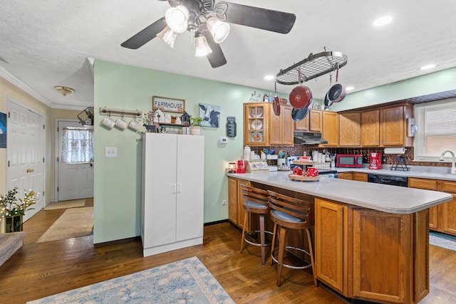 kitchen featuring tasteful backsplash, black dishwasher, a kitchen breakfast bar, and kitchen peninsula