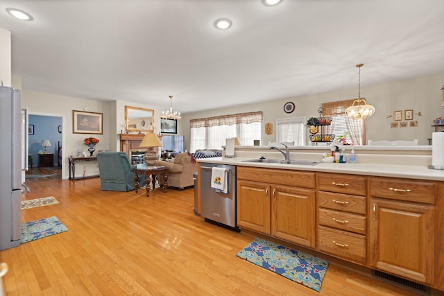 kitchen featuring appliances with stainless steel finishes, sink, pendant lighting, and a notable chandelier