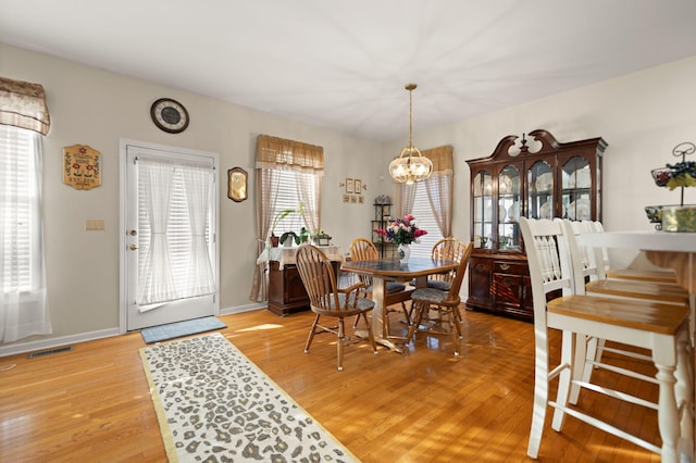 dining area featuring an inviting chandelier and light hardwood / wood-style floors