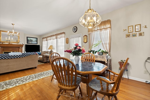 dining area featuring light wood-type flooring and a chandelier