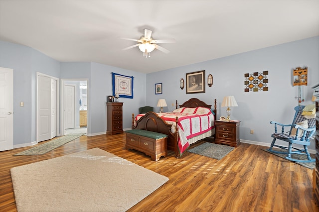 bedroom with connected bathroom, hardwood / wood-style floors, and ceiling fan