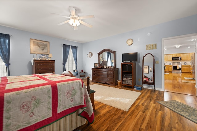 bedroom with multiple windows, wood-type flooring, and ceiling fan