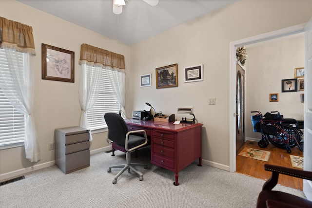carpeted home office featuring ceiling fan