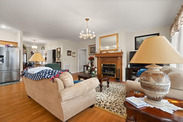 living room with a notable chandelier and light hardwood / wood-style flooring