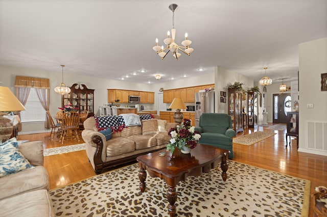 living room featuring light hardwood / wood-style floors and a notable chandelier