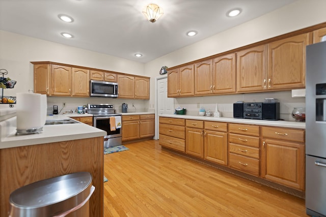 kitchen featuring stainless steel appliances and light hardwood / wood-style floors