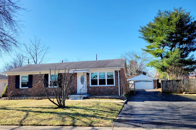 ranch-style home featuring an outbuilding, brick siding, a front lawn, and fence