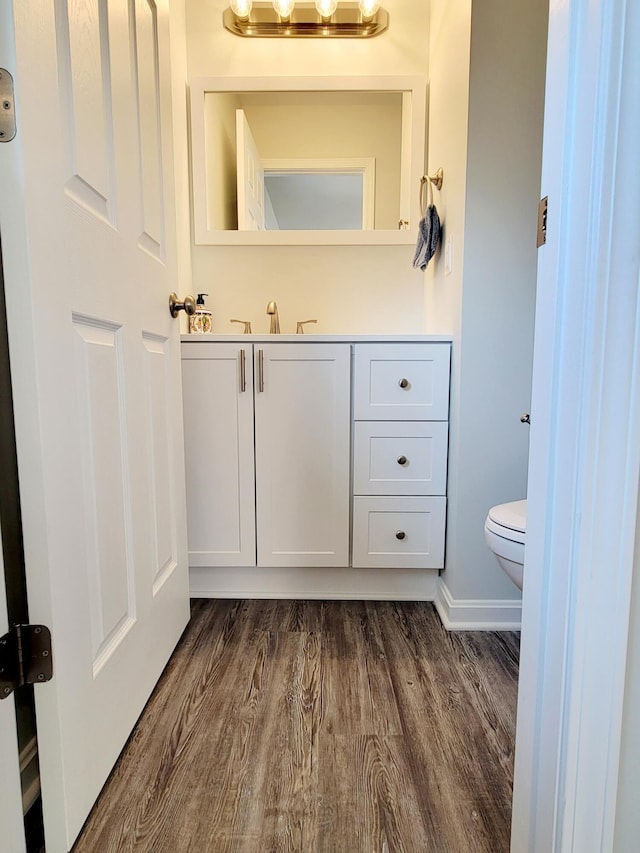 bathroom featuring hardwood / wood-style flooring, vanity, and toilet