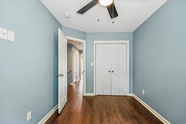 unfurnished bedroom featuring a closet, dark hardwood / wood-style floors, and ceiling fan