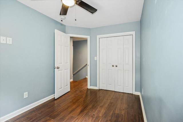 unfurnished bedroom with dark hardwood / wood-style floors, ceiling fan, and a closet