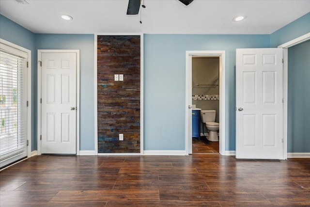 unfurnished bedroom with ensuite bath and dark hardwood / wood-style floors