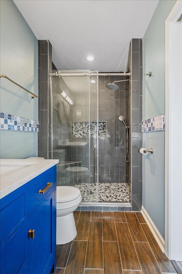 bathroom featuring vanity, an enclosed shower, and toilet