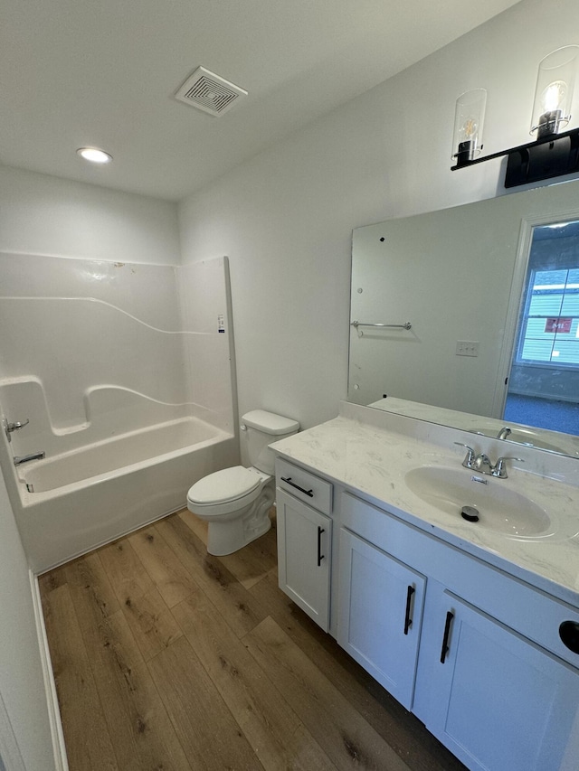 full bathroom featuring vanity, tub / shower combination, hardwood / wood-style floors, and toilet