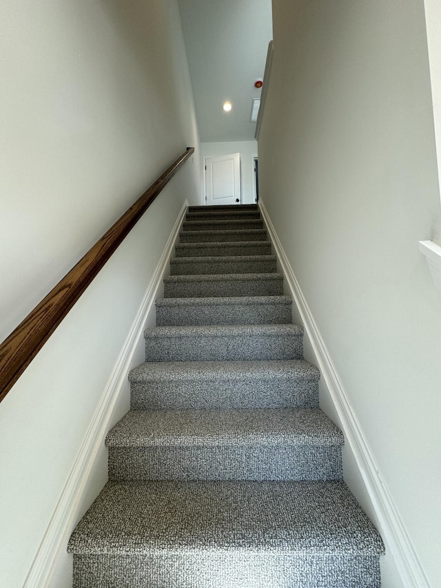 stairway featuring carpet flooring