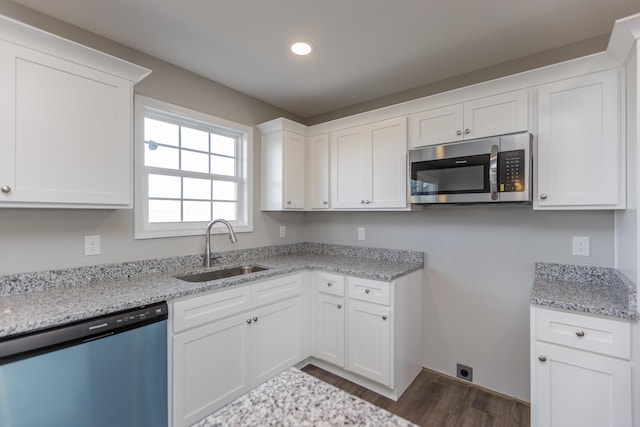 kitchen featuring white cabinetry, sink, light stone countertops, and appliances with stainless steel finishes