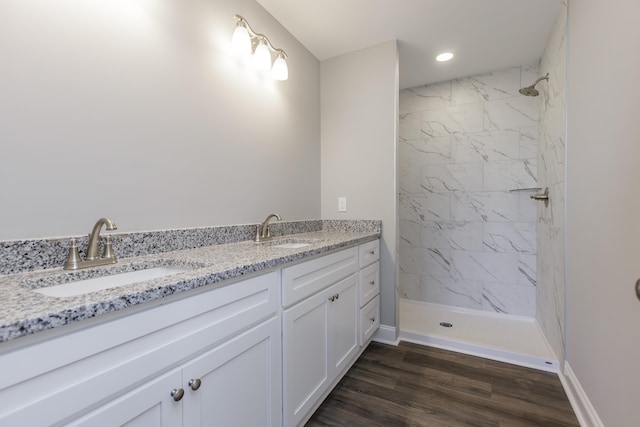 bathroom with vanity, hardwood / wood-style flooring, and tiled shower