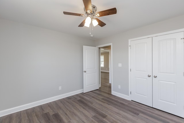 unfurnished bedroom with ceiling fan, dark hardwood / wood-style floors, and a closet