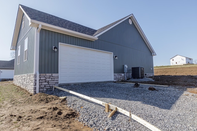 view of side of property featuring a garage and central AC