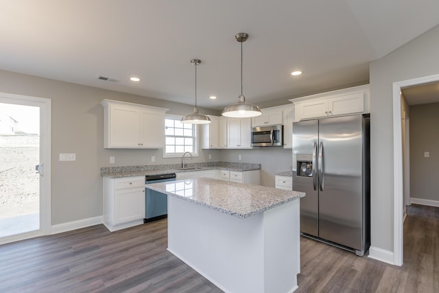 kitchen with sink, stainless steel appliances, white cabinets, and a kitchen island