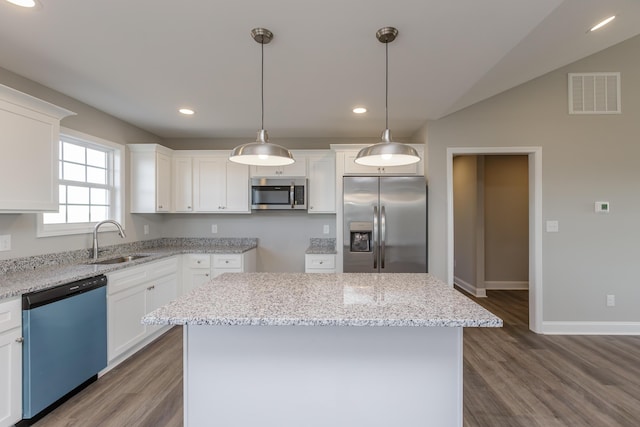 kitchen with sink, a center island, white cabinets, and appliances with stainless steel finishes