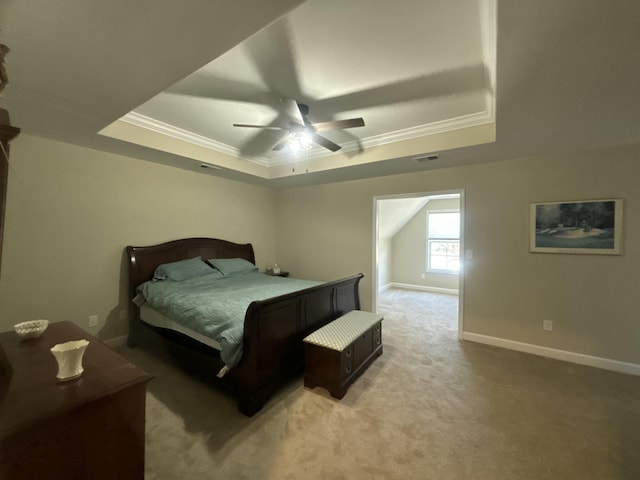 carpeted bedroom with ceiling fan and a tray ceiling