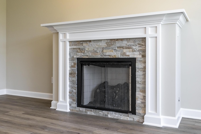 interior details featuring hardwood / wood-style flooring and a stone fireplace