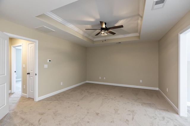 unfurnished room with light colored carpet, ornamental molding, a raised ceiling, and ceiling fan