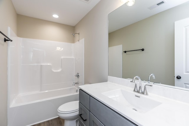 full bathroom with  shower combination, hardwood / wood-style floors, vanity, and toilet