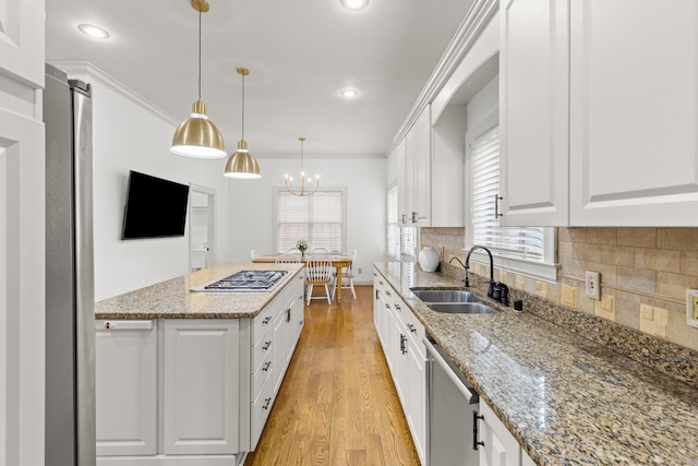 kitchen featuring sink, stone counters, hanging light fixtures, stainless steel appliances, and white cabinets