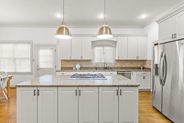 kitchen with hanging light fixtures, white cabinets, and appliances with stainless steel finishes